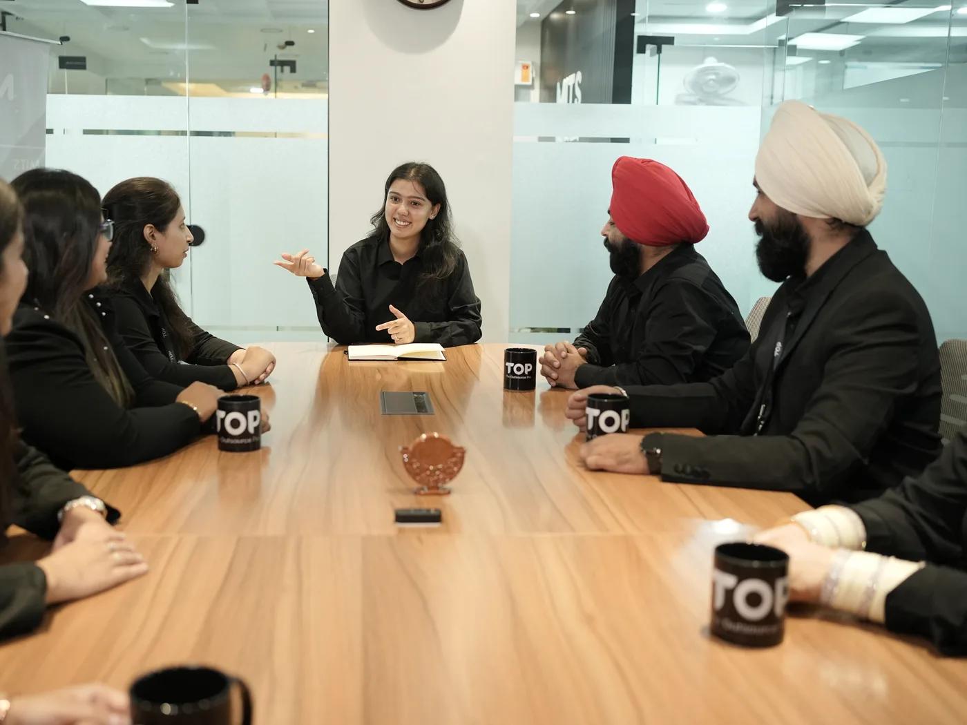 A TOP team member leading a discussion around the meeting table
