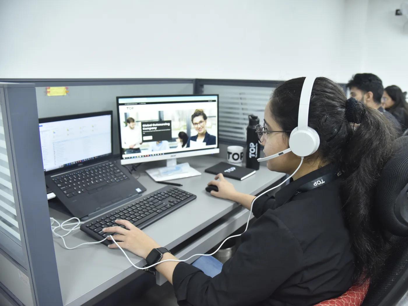 A TOP team member on a support call at their workstation