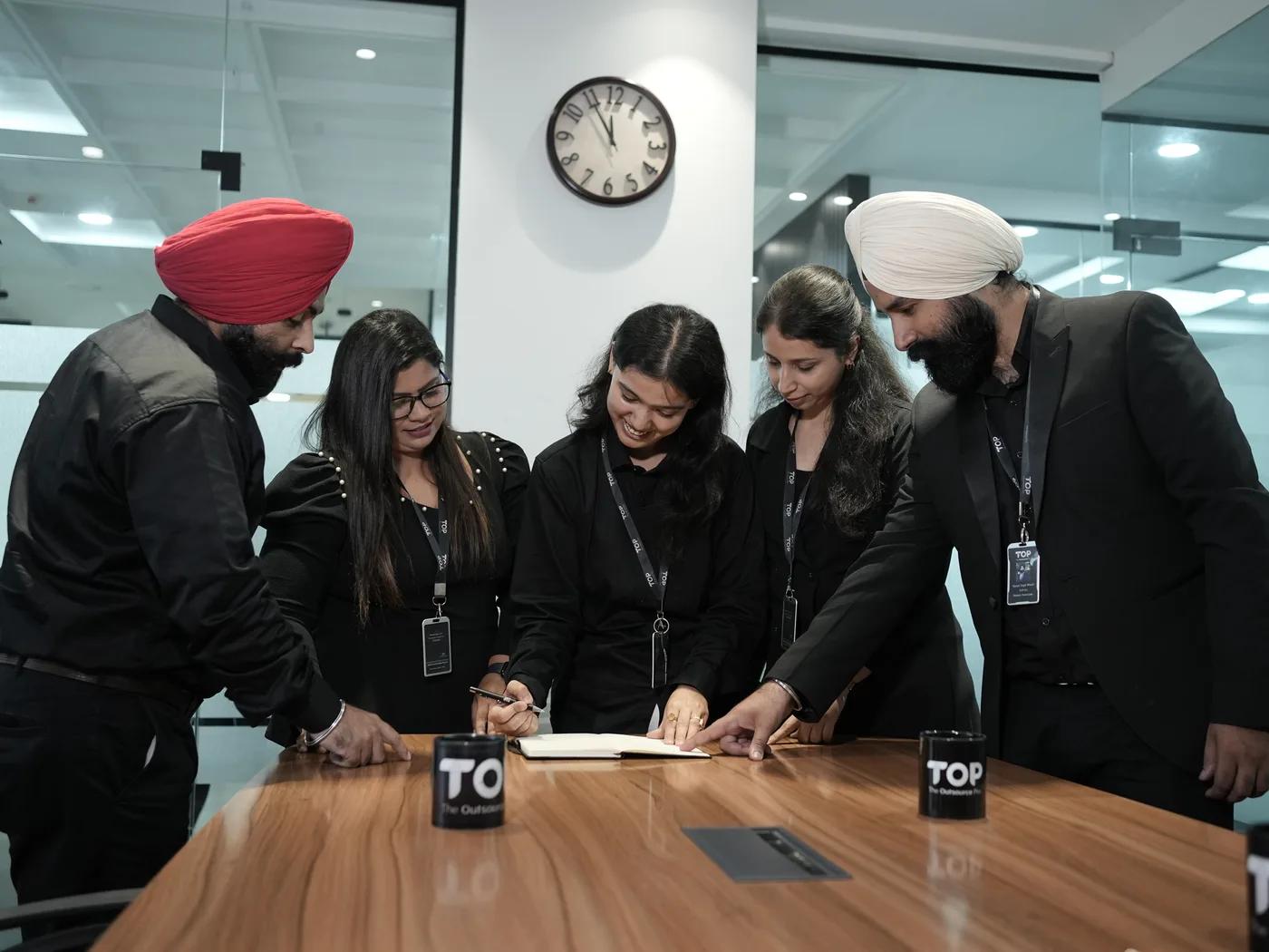 TOP team members sharing a laugh while working around a table