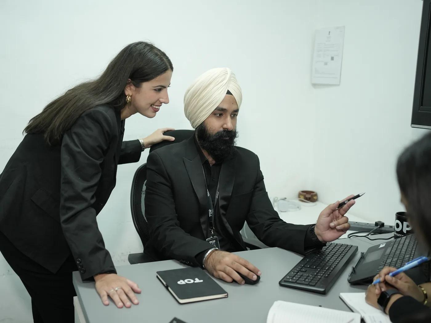 Two TOP colleagues reviewing work together at a desk